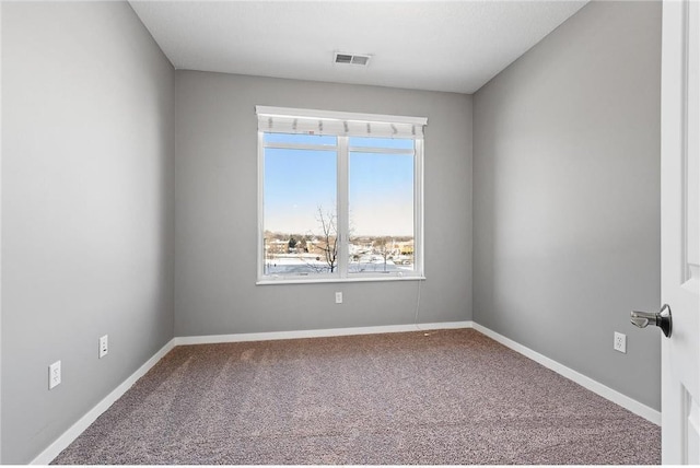 carpeted spare room with visible vents and baseboards