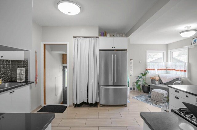 2136 Temple Ct, Saint Paul, MN 55104 - kitchen featuring freestanding refrigerator, dark countertops, white cabinets, and a sink