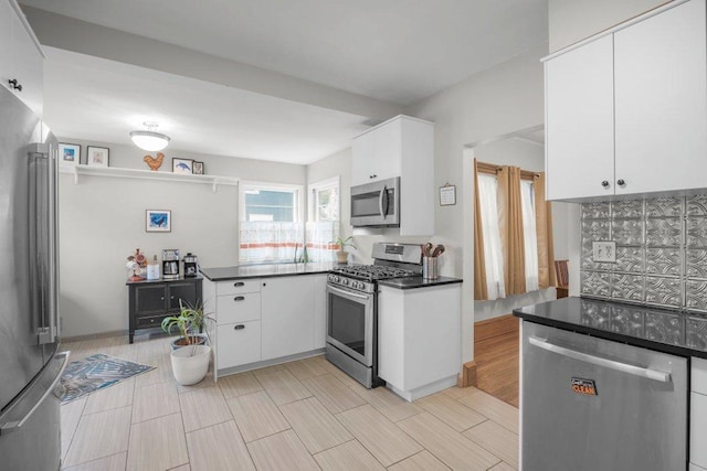 2136 Temple Ct, Saint Paul, MN 55104 - kitchen featuring appliances with stainless steel finishes, dark countertops, tasteful backsplash, and white cabinetry