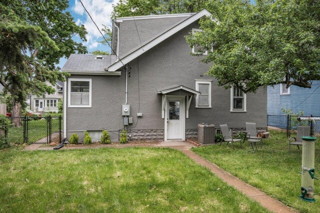 2136 Temple Ct, Saint Paul, MN 55104 - back of property with central air condition unit, a gate, and stucco siding