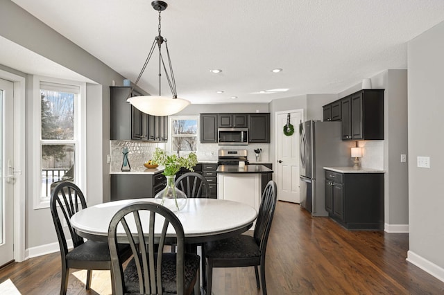 dining room with dark wood-type flooring, recessed lighting, and baseboards