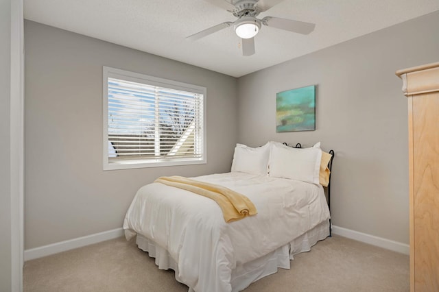 bedroom with light colored carpet, a ceiling fan, and baseboards