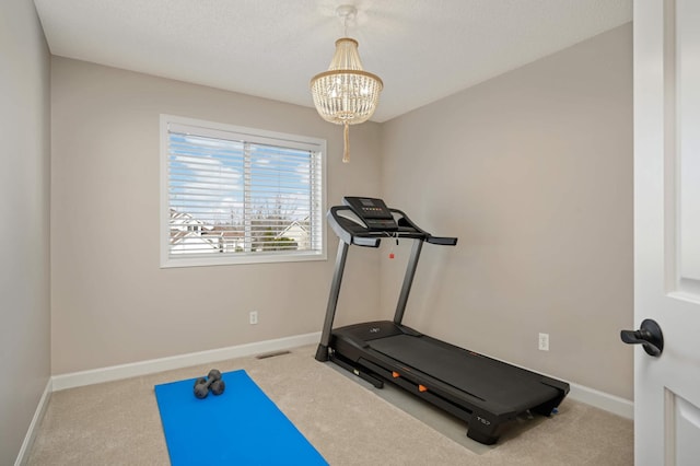 workout area with visible vents, baseboards, a notable chandelier, and carpet