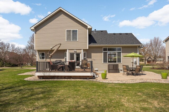back of property with a patio, a shingled roof, a yard, and a deck