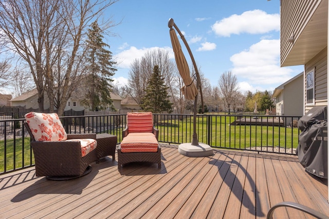 wooden terrace featuring a lawn and a fenced backyard