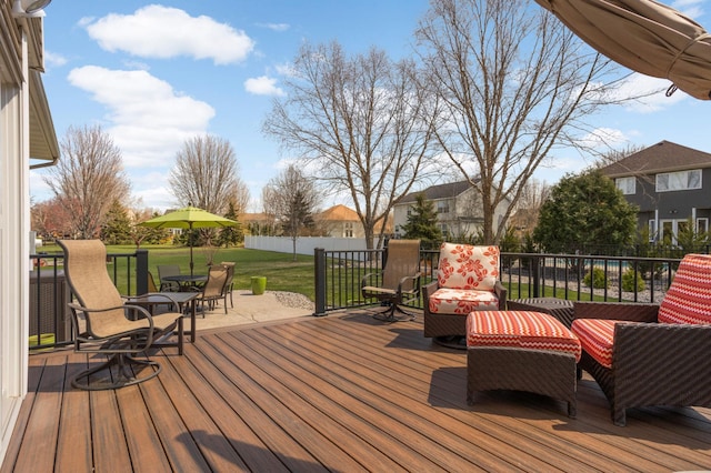 wooden deck featuring a lawn and fence