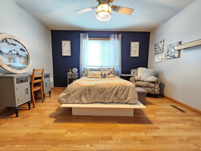 728 Elm St, Belle Plaine, MN 56011 - bedroom featuring visible vents, a textured ceiling, baseboards, and light wood-style flooring
