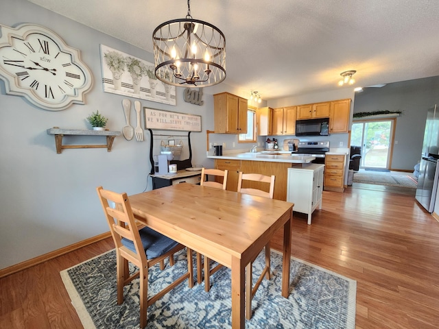 728 Elm St, Belle Plaine, MN 56011 - dining space featuring light wood-style flooring, an inviting chandelier, and baseboards