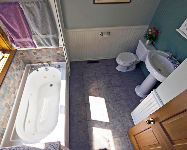 32990 Heilberger Dr, Erhard, MN 56534 - bathroom featuring a tub with jets, toilet, tile patterned flooring, and a sink