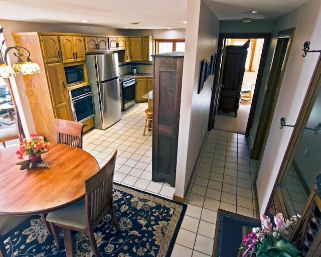 32990 Heilberger Dr, Erhard, MN 56534 - kitchen featuring stainless steel appliances, light tile patterned floors, brown cabinetry, recessed lighting, and light countertops