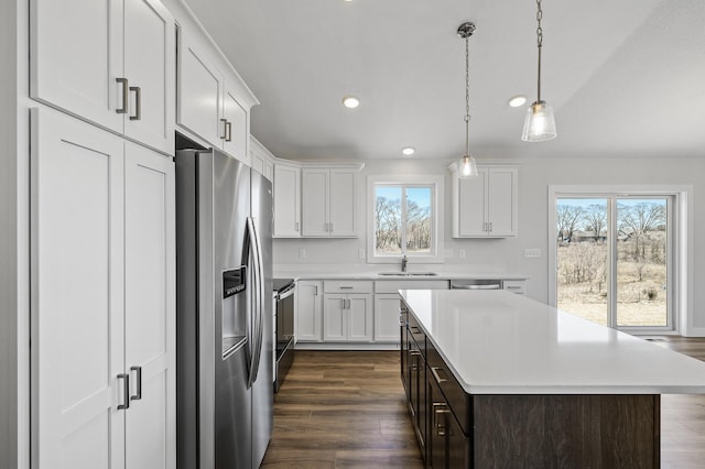 kitchen featuring stainless steel fridge with ice dispenser, white cabinetry, dark wood-style flooring, light countertops, and range with electric stovetop