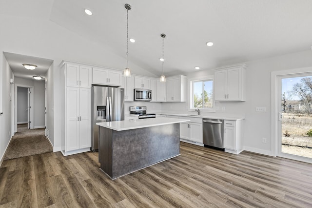 kitchen with a center island, light countertops, white cabinetry, appliances with stainless steel finishes, and a sink