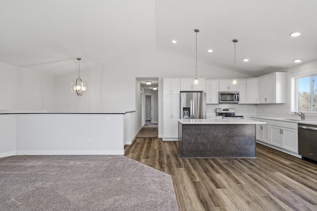 kitchen featuring white cabinets, a center island, a sink, and appliances with stainless steel finishes