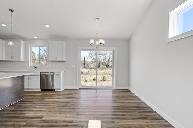 kitchen featuring a chandelier, stainless steel dishwasher, light countertops, and white cabinets