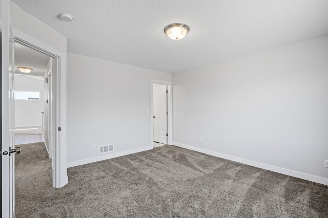 unfurnished bedroom with visible vents, baseboards, carpet, and a textured ceiling