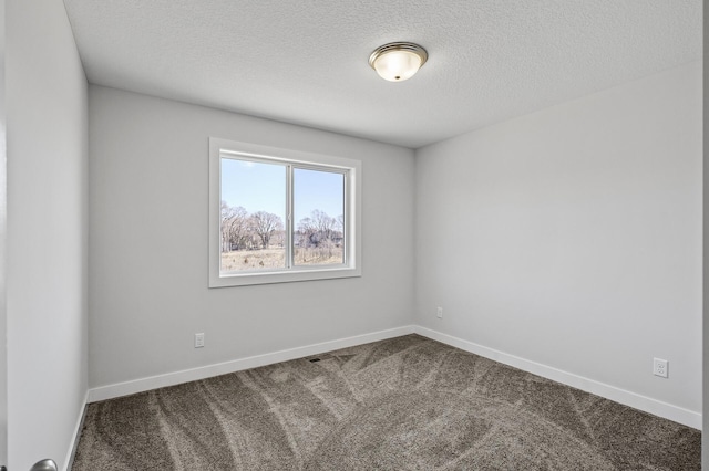 carpeted spare room with baseboards and a textured ceiling