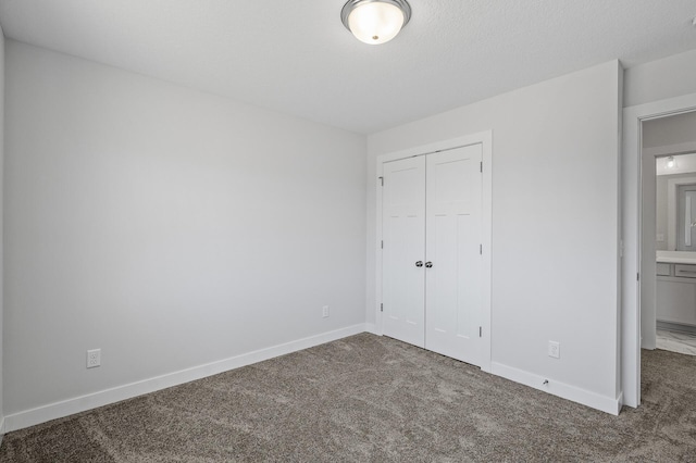 unfurnished bedroom with a closet, carpet flooring, and baseboards
