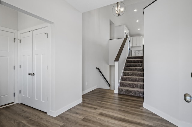 staircase featuring a chandelier, wood finished floors, baseboards, and recessed lighting