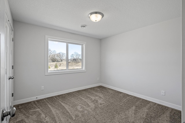 unfurnished room with baseboards, carpet, and a textured ceiling