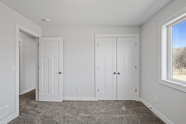 unfurnished bedroom featuring visible vents, carpet, and a textured ceiling