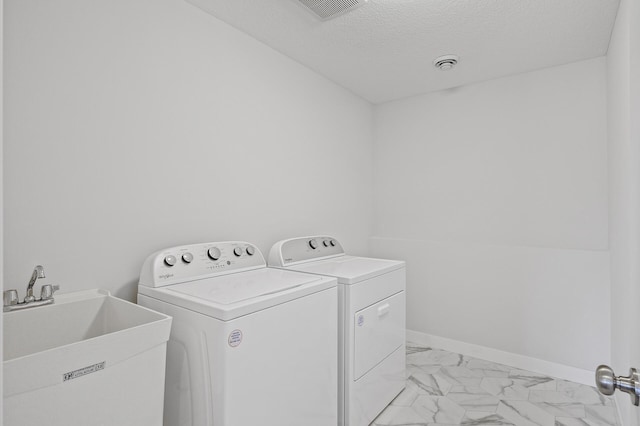 washroom with laundry area, a textured ceiling, marble finish floor, a sink, and washer and clothes dryer