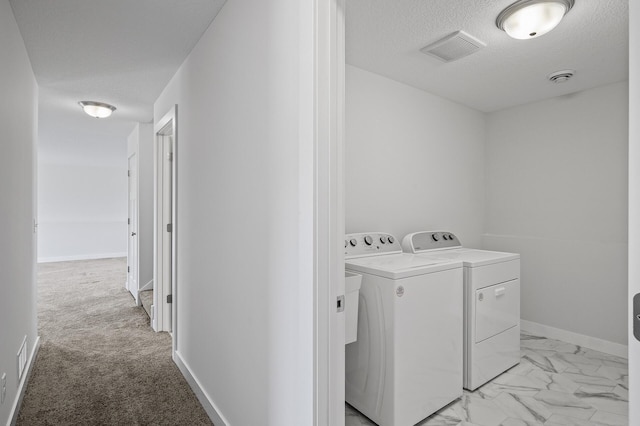 washroom with visible vents, laundry area, a textured ceiling, washing machine and clothes dryer, and marble finish floor