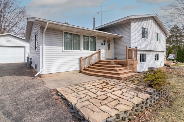 103 8th St N, Sartell, MN 56377 - tri-level home with a detached garage, an outbuilding, and aphalt driveway