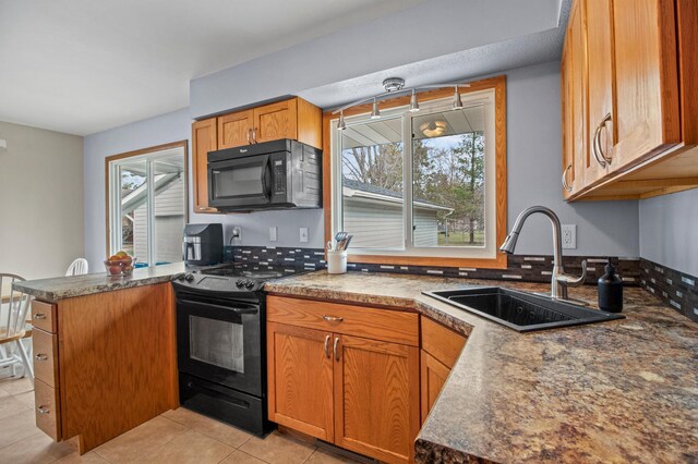 103 8th St N, Sartell, MN 56377 - kitchen with dark countertops, a sink, black appliances, light tile patterned flooring, and a peninsula