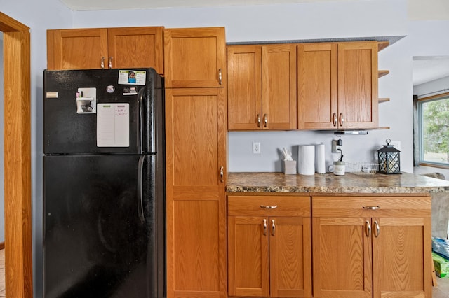 103 8th St N, Sartell, MN 56377 - kitchen featuring stone countertops, brown cabinets, open shelves, and freestanding refrigerator