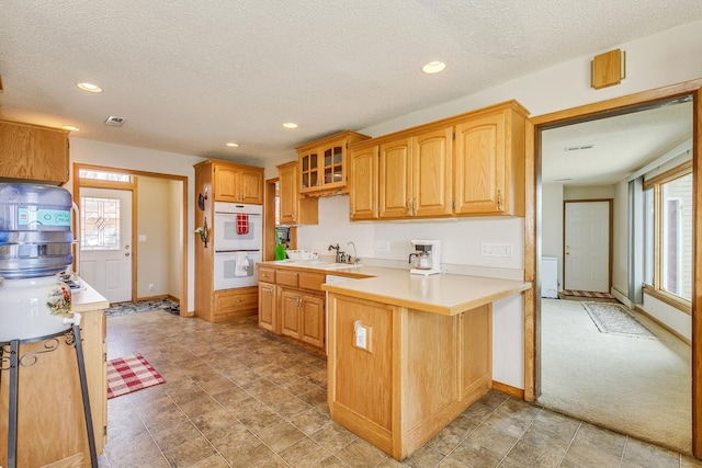 50568 Lakeside Cir, Rush City, MN 55069 - kitchen featuring white double oven, a peninsula, light countertops, recessed lighting, and a textured ceiling