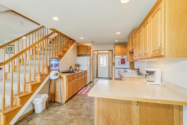 50568 Lakeside Cir, Rush City, MN 55069 - kitchen featuring white appliances, a peninsula, light countertops, recessed lighting, and a textured ceiling