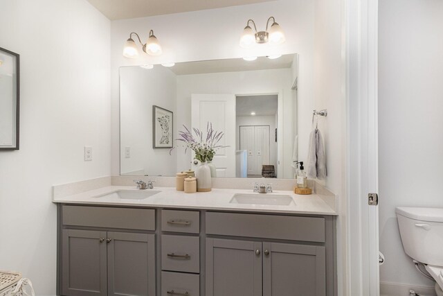 full bath featuring double vanity, toilet, and a sink
