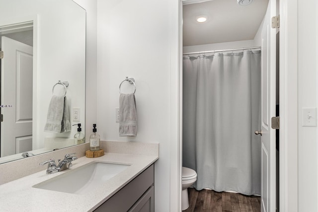 bathroom featuring toilet, wood finished floors, vanity, and a shower with shower curtain