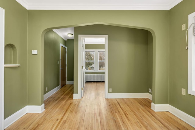 4348 Minnehaha Ave, Minneapolis, MN 55406 - empty room with radiator, arched walkways, light wood finished floors, crown molding, and baseboards