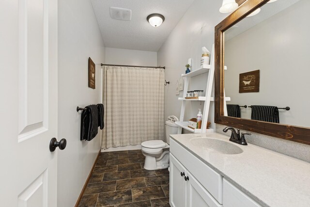 full bath featuring vanity, visible vents, toilet, a shower with shower curtain, and stone finish flooring