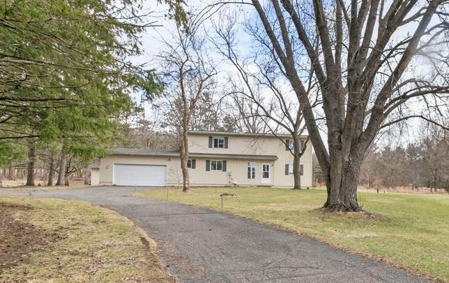 traditional-style home featuring a front yard, driveway, and an attached garage