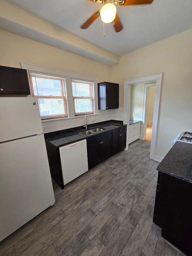 kitchen featuring ceiling fan, dark wood finished floors, white appliances, dark cabinets, and a sink
