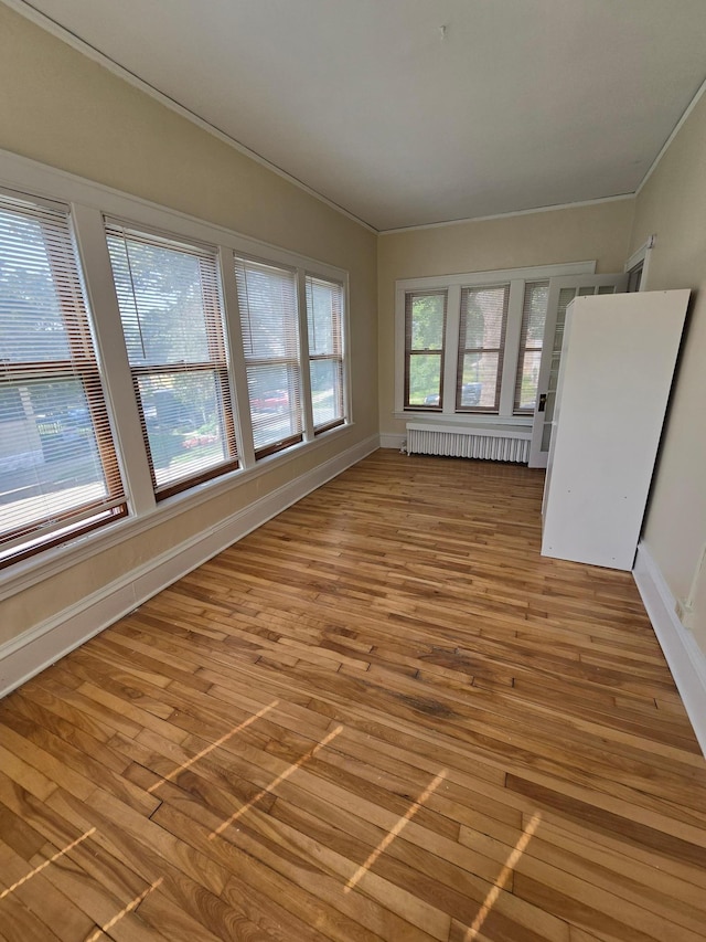 unfurnished sunroom featuring plenty of natural light, a baseboard radiator, and radiator