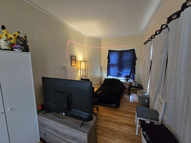 living area with crown molding and hardwood / wood-style flooring