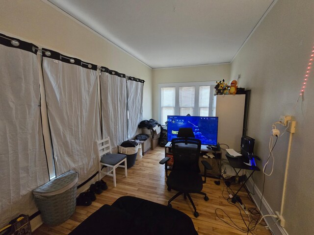 home office featuring crown molding, wood finished floors, and baseboards
