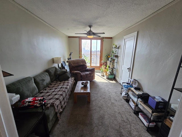 living area featuring a ceiling fan, a textured wall, a textured ceiling, crown molding, and carpet flooring