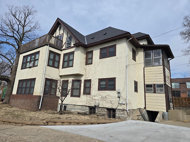 view of side of home featuring stucco siding and a balcony