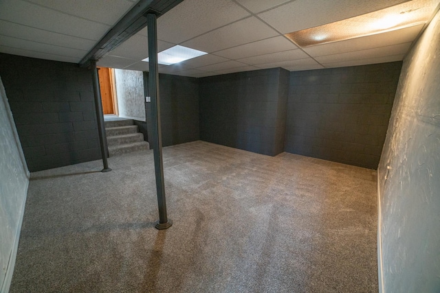finished below grade area featuring carpet floors, concrete block wall, and stairway