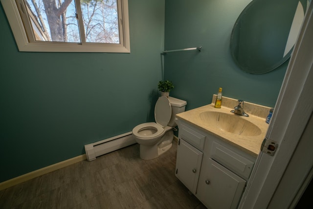 half bath featuring toilet, a baseboard radiator, vanity, and baseboards