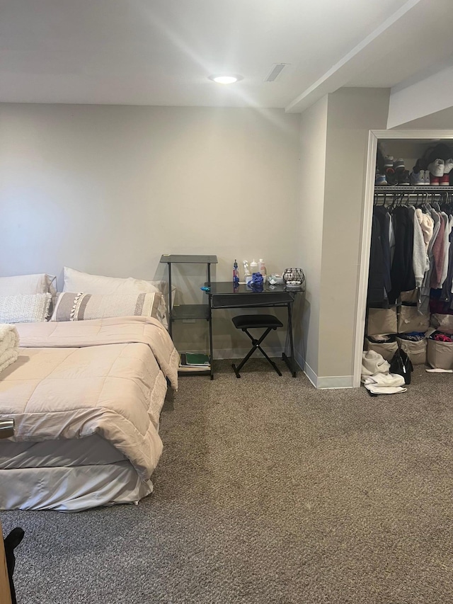 carpeted bedroom with a closet, baseboards, and a spacious closet