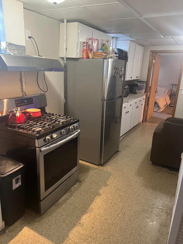 kitchen with a paneled ceiling, light floors, white cabinets, appliances with stainless steel finishes, and light countertops