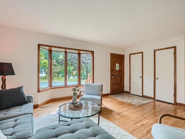 living room featuring baseboards and light wood-type flooring