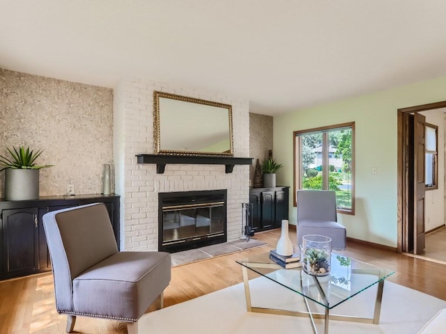 living room with baseboards, a fireplace, and light wood-style flooring