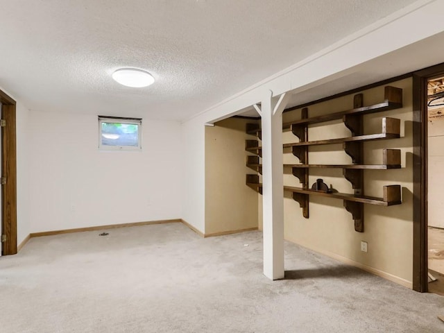 basement with carpet floors, baseboards, and a textured ceiling