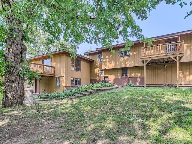 rear view of property with a yard and a balcony